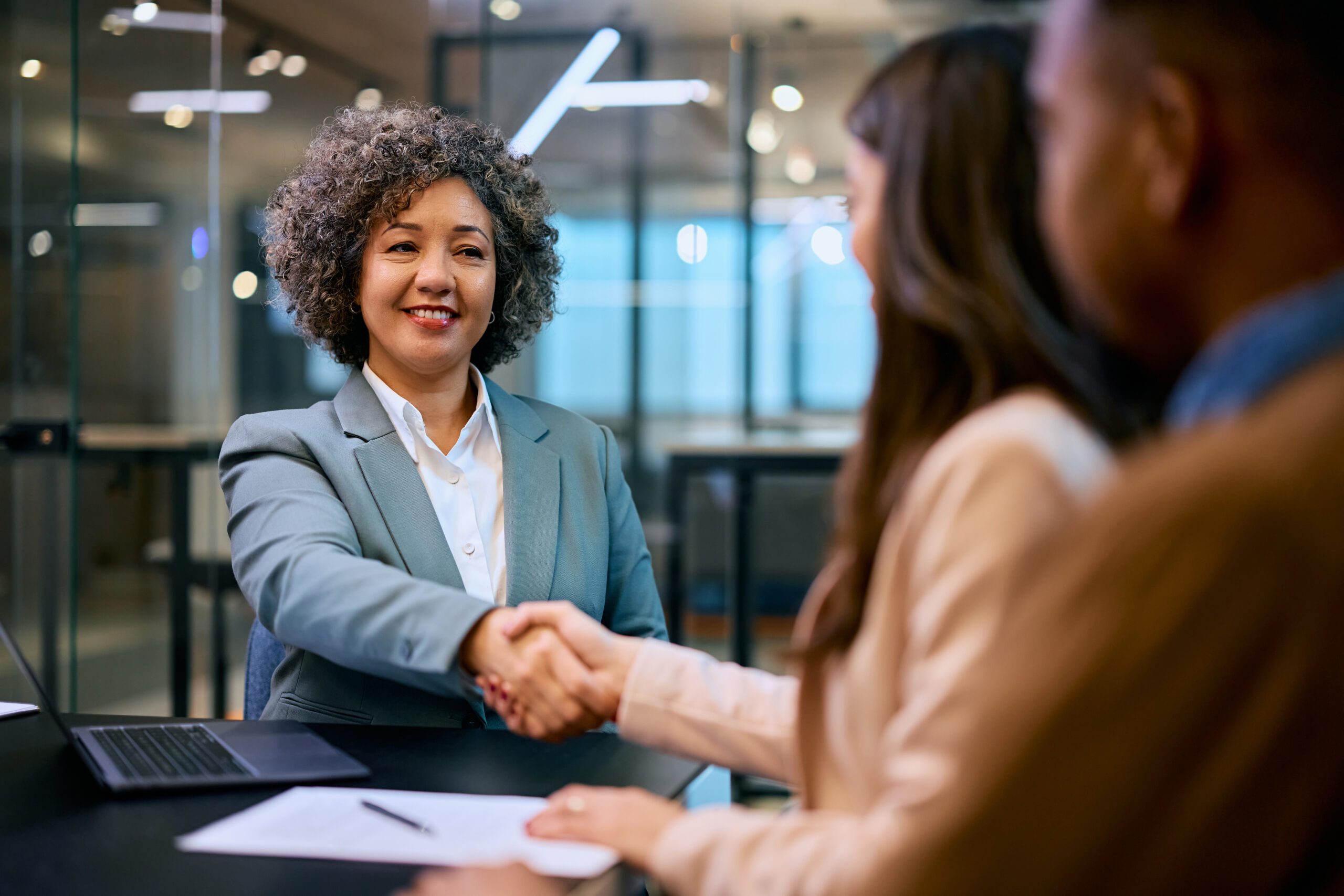 woman banker shaking hands with clients
